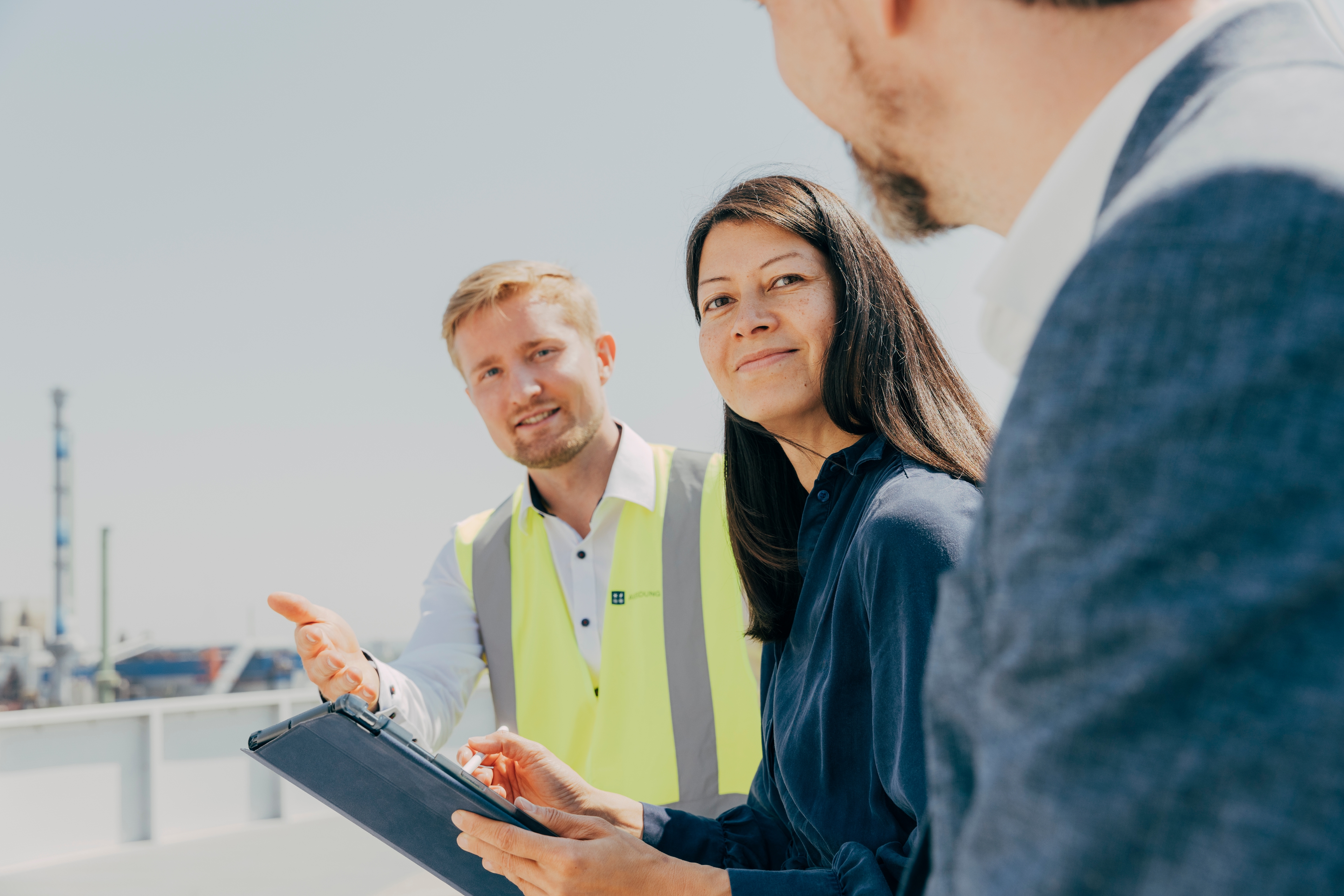 Brandingfoto – Erneuerbare Energien – drei Mitarbeitende in Gesprächssituation draußen